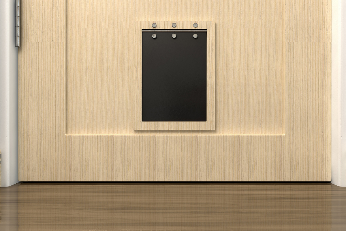 Une chatière noire dans une porte en bois marron clair. La chatière est pour les chiens