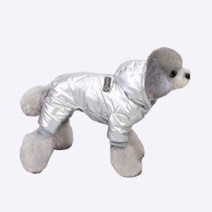 Doudoune pour chien de couleur grise porté par un chien au pelage gris sur un sol gris et à côté d'un meuble blanc et jaune et d'un tapis blanc et noir, et d'un autre tapis de couleur beige