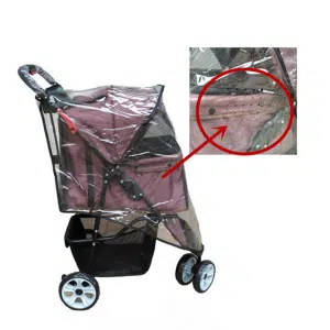 Un chariot pour chien rose et noir avce une housse de protection en plastique, sur fond blanc.