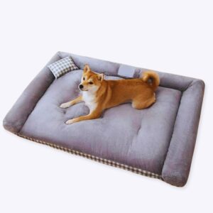 Un chien est installé en train de dormi sur un lit/canapé pour chien molletonné, gris,
