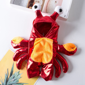 déguisement halloween pour chien représentant un crabe rouge avec deux antennes avec des yeux, présenté à plat sur une table blanche