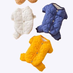 3 doudounes matelassées pour chien de couleurs blanche, jaune et bleue posées sur un tapis blanc.